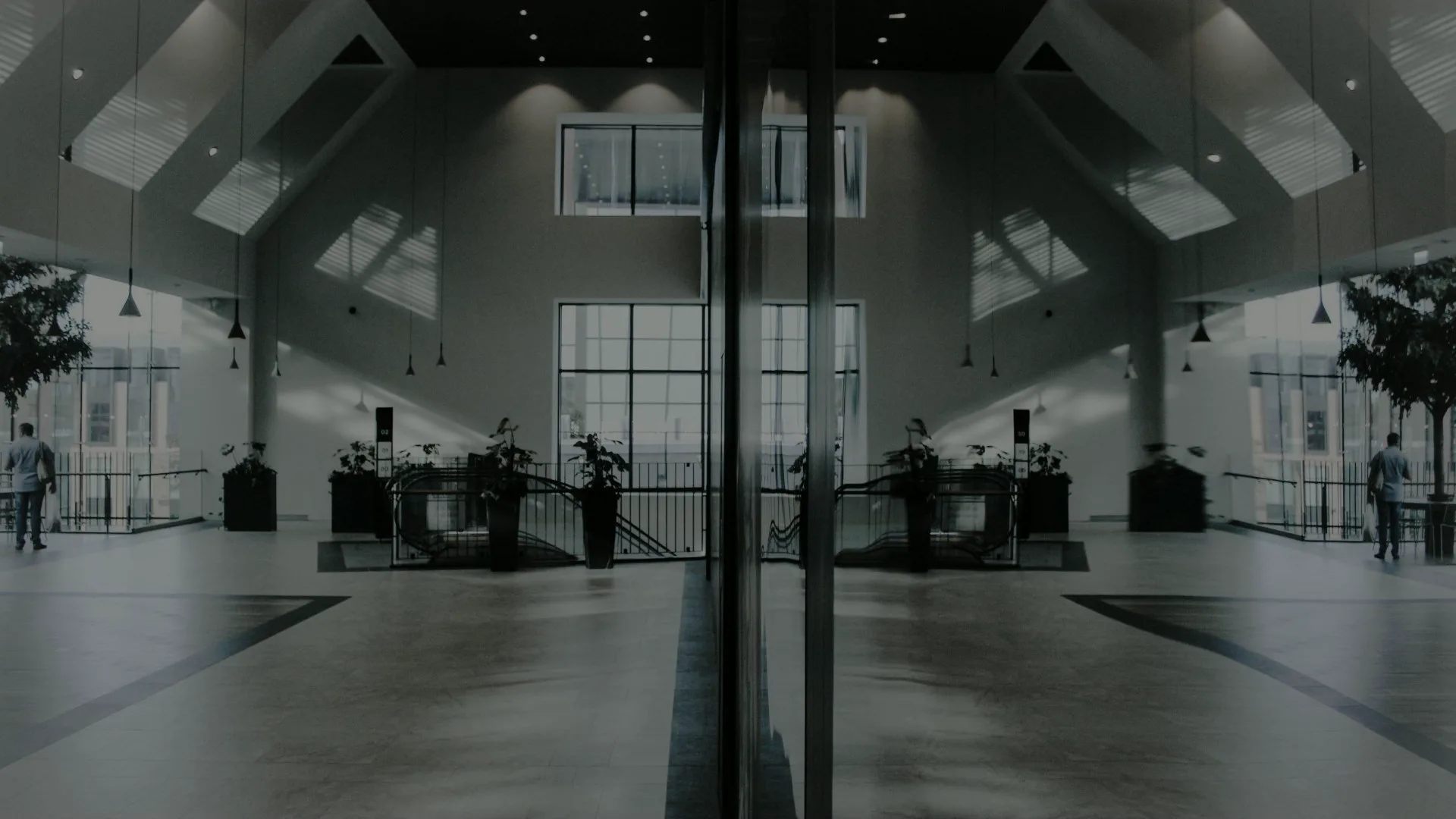 A symmetrical, light-filled building lobby with tall windows